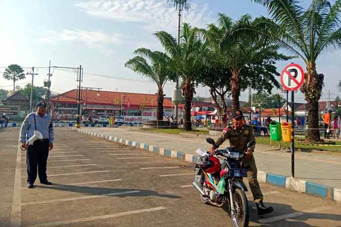 BUKAN LOKASI PARKIR: Personel Satpol PP membawa motor yang parkir di tepi Alun-alun Minggu (7/5) pagi. (Foto: M Busthomi/Jawa Pos Radar Bromo)