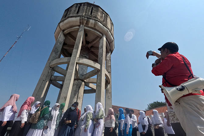 PUNYA NILAI HISTORI: Para pelajar saat dikenalkan dengan bangunan cagar budaya menara air atau water toren di kawasan Alun-alun Kota Pasuruan, (24/5). (Mokhamad Zubaidillah/Radar Bromo)