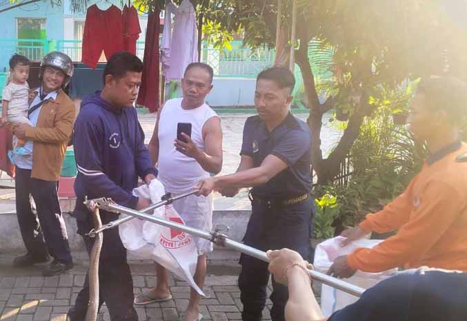 DITANGKAP: Sejumlah petugas Damkar Kota Pasuruan berhasil menangkap seekor ular kobra di Bakalan, Kecamatan Bugul Kidul, Jumat (9/6) pagi. (Foto : BPBD Kota Pasuruan for Jawa Pos Radar Bromo)