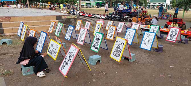 SIAP DIWARNAI: Seorang bocah siap mewarnai salah satu gambar yang disediakan di Alun-alun Kota Probolinggo. (Arif Mashudi/Jawa Pos Radar Bromo)