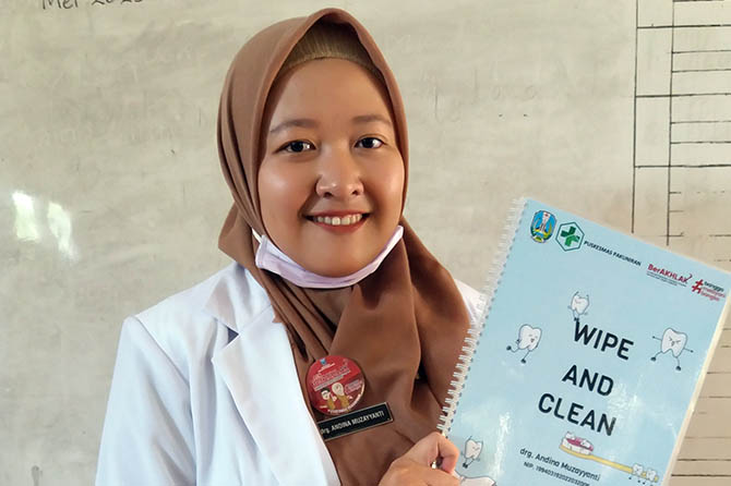 INOVATOR: Drg. Andina Muzayyanti menunjukkan buku Inovasi Wipe and Clean. Di dalamnya ada gambar kartun yang harus dicoret-coret warna giginya. Kemudian, dihapus sesuai arahan. (Jamaludin/Radar Bromo)