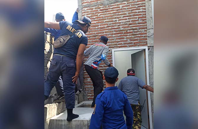 EVAKUASI: Tim Damkar Satpol PP Kota Probolinggo ketika memburu ular di rumah Rahmat, Kamis (15/6). (Damkar-Satpol PP Kota Probolinggo for Jawa Pos Radar Bromo)