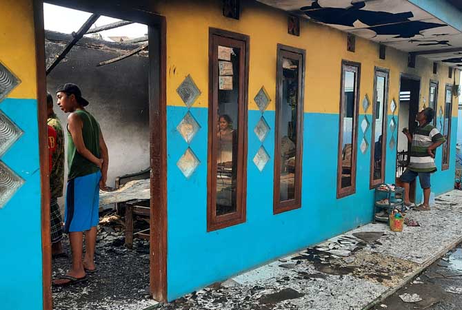 BERSEBELAHAN: Rumah kakak beradik Slamet, 50, dan Eko, 52, yang bersebelahan di Desa Sumberkedawung, Kecamatan Leces, terbakar hebat, Sabtu (17/6). (Fahrizal Firmani/ Radar Bromo)