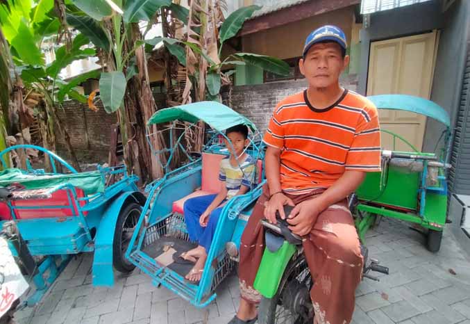 LALUI KISAH KELAM: Rachmad Hidayat tampak sederhana saat ditemu di tempat becaknya yang ada di Kiduldalem, Kecamatan Bangil. (Foto: Iwan Andrik/Jawa Pos Radar Bromo)