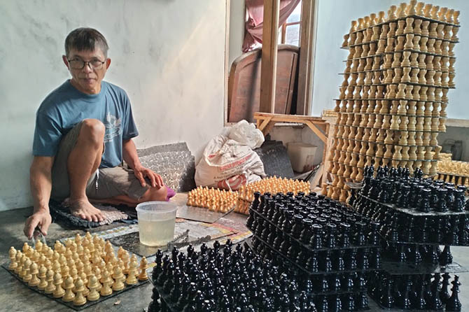 SAMPAI LUAR NEGERI: Ahmad Kosim, 54, menunjukkan buah catur produksi home industry miliknya. Buah catur itu dipasarkan ke sejumlah kota besar di dalam negeri, juga ke sejumlah negara di luar negeri. (Rizal F. Syatori/Radar Bromo)