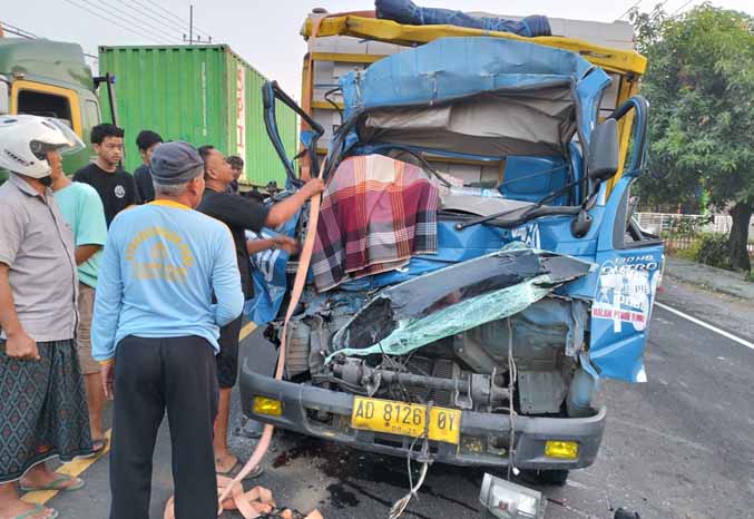 TERJEPIT: Sopir truk yang tewas di belakang kemudi, sebelum dievakuasi. Kecelakaan  yang terjadi di Desa Karangsono, Kecamatan Sukorejo ini melibatkan empat kendaraan. (Foto: Rizal F Syatori/Jawa Pos Radar Bromo)