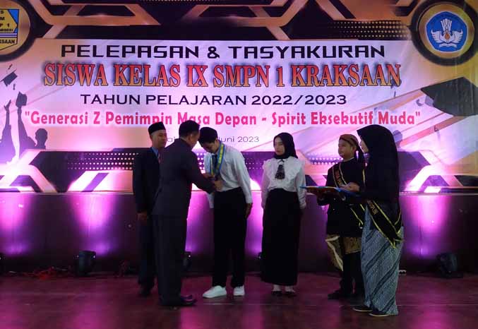 SIMBOLIS: Kepala SMPN 1 Kraksaan Nur Nuhud, S.Ag., M.M. didampingi Ketua Komite SMPN 1 Kraksaan, mengalungkan gordon kepada siswa. (Foto: Didik Purwanto/Jawa Pos Radar Bromo)