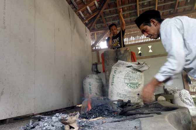 RATUSAN TAHUN: Muhammad Jufri dan putranya, Junaedi, 37, saat membuat gaman atau sajam. Pembuatan dilakukan dengan cara yang sama selama 200 tahun terakhir. (Foto: Mukhamad Rosyidi/Jawa Pos Radar Bromo)
