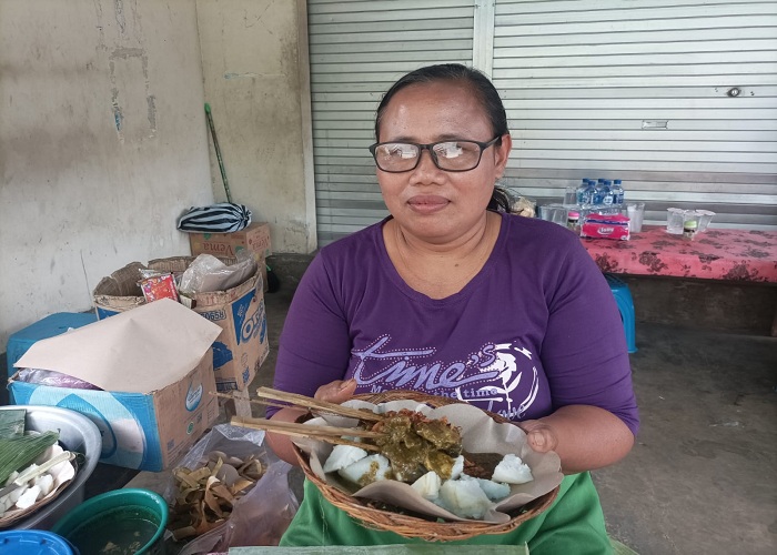 RAMAI : Ni Ketut Bagiani alias Jero Bagiani saat menghidangkan sate serapah legend Gianyar Jumat (21/7).
