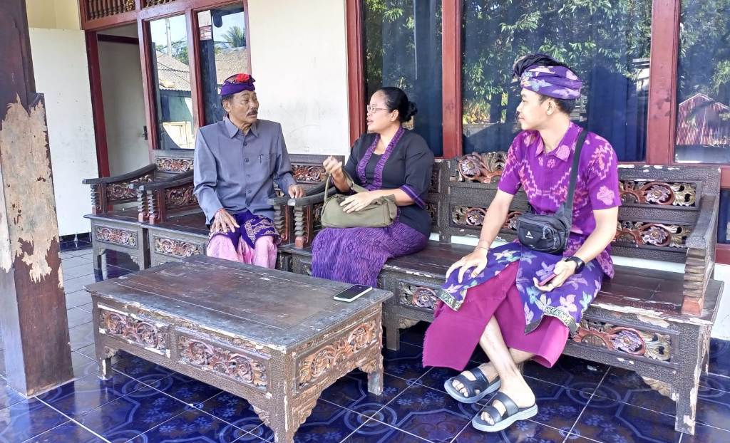 KOORDINASI: Petugas Disbudpar Karangasem melakukan koordinasi dengan Bendesa Adat Purwayu, I Nyoman Jati (kiri) terkait kasus bule berciuman di Pura Lempuyang.