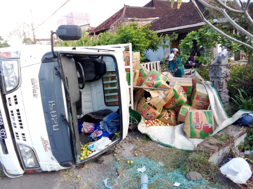 TERGULING : Truk pengangkut buah apel yang terguling di Desa Banyubiru, Kecamatan Negara, Jembrana, Bali Jumat (28/7).
