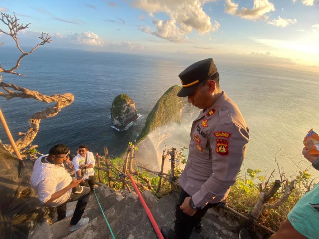 PEMADAMAN API: Tim Kepolisian Nusa Penida dan Anggota damkar memadamkan api yang membakar semak belukar tebing KElingking Beach, Nusa Penida, Klungkung, Bali Minggu  (30/7)