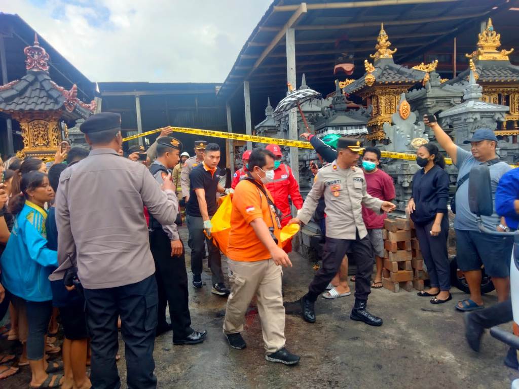 EVAKUASI: Jenazah KS, bocah  9 tahun,  dievakuasi setelah insiden kebakaran yang meludeskan gudang usaha pembuatan sanggah di Darmasaba.
