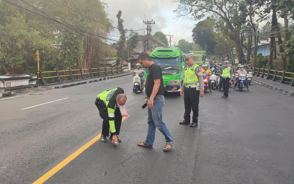 Petugas dari Polsek Kediri melakukan reka ulang di lokasi kecelakaan antara  bus pariwisata dan sepeda motor di jalan A. Yani Kecamatan Kediri, Tabanan, Bali.