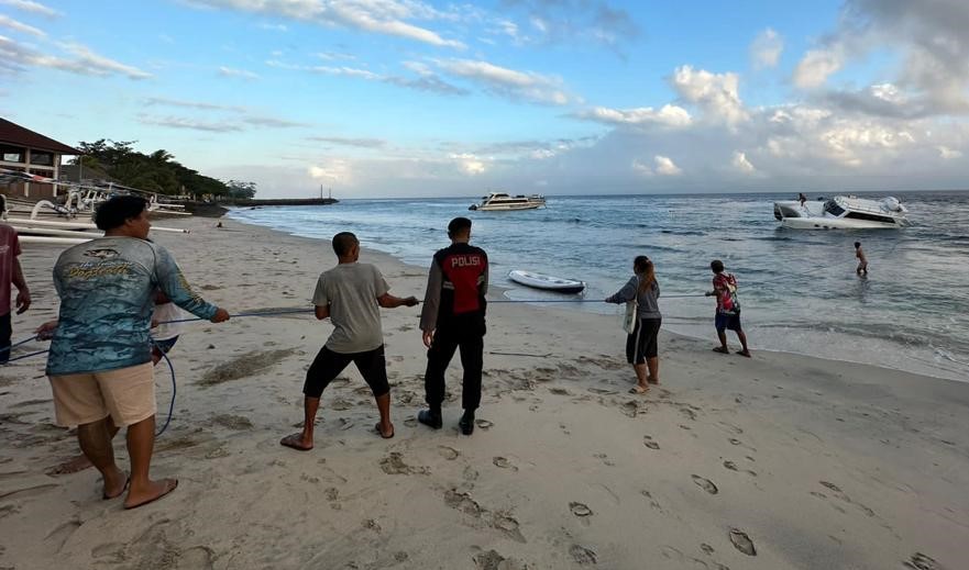 Warga berusaha menarik fast boat yang karam di Nusa Penida.