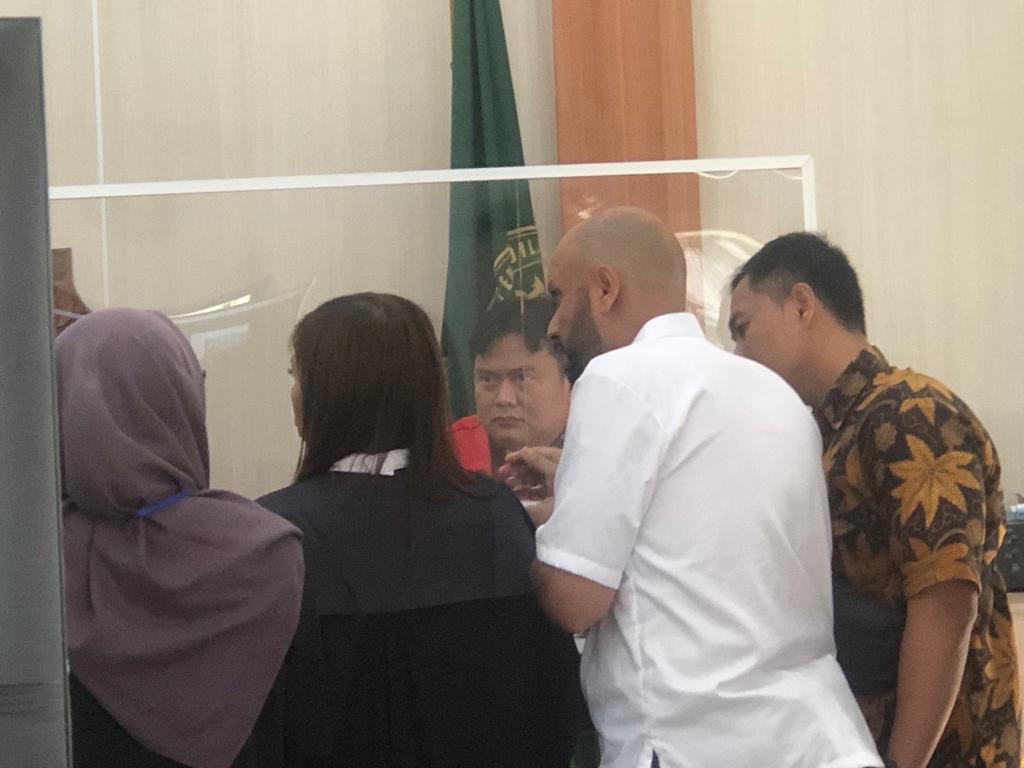 Mohamed Salah Hussain (baju putih) memeriksa paspor dalam sidang lanjutan kasus paspor palsu, Kamis (10/8).
