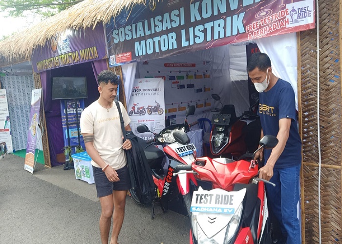 KONVERSI : Pengunjung tengah melihat konversi motor dari bahan bakar minyak (BBM) menjadi listrik, Selasa (15/8).