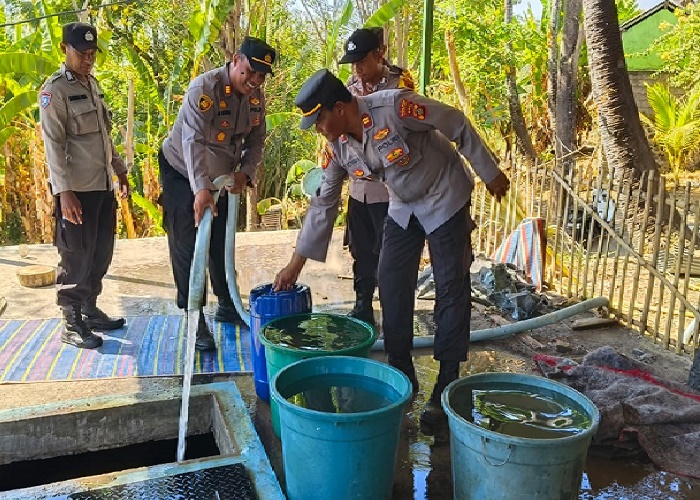 AIR BERSIH: Personil Polsek Kubu memberikan air bersih kepada warga Banjar Dinas Munti Gunung, Desa Tianyar Barat, Kubu, pada Selasa (22/8).