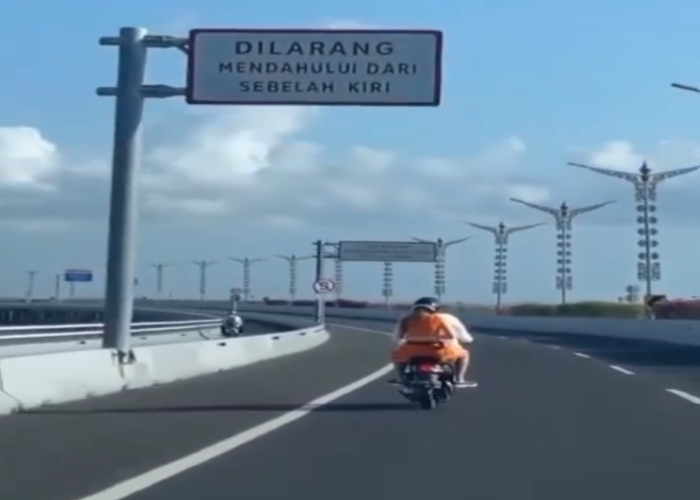 SALAH JALUR: Pasangan wisatawan asing yang mengendarai sepeda motor namun masuk ke jalur roda empat di Tol Bali Mandara, Senin (28/8).