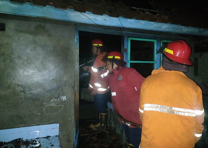 PEMADAMAN: Petugas Damkartan Karangasem melakukan pemadaman api di dapur milik I Wayan Merta di Desa Bugbug, Karangasem yang mengalami peristiwa kebakaran, pada Rabu (30/8).