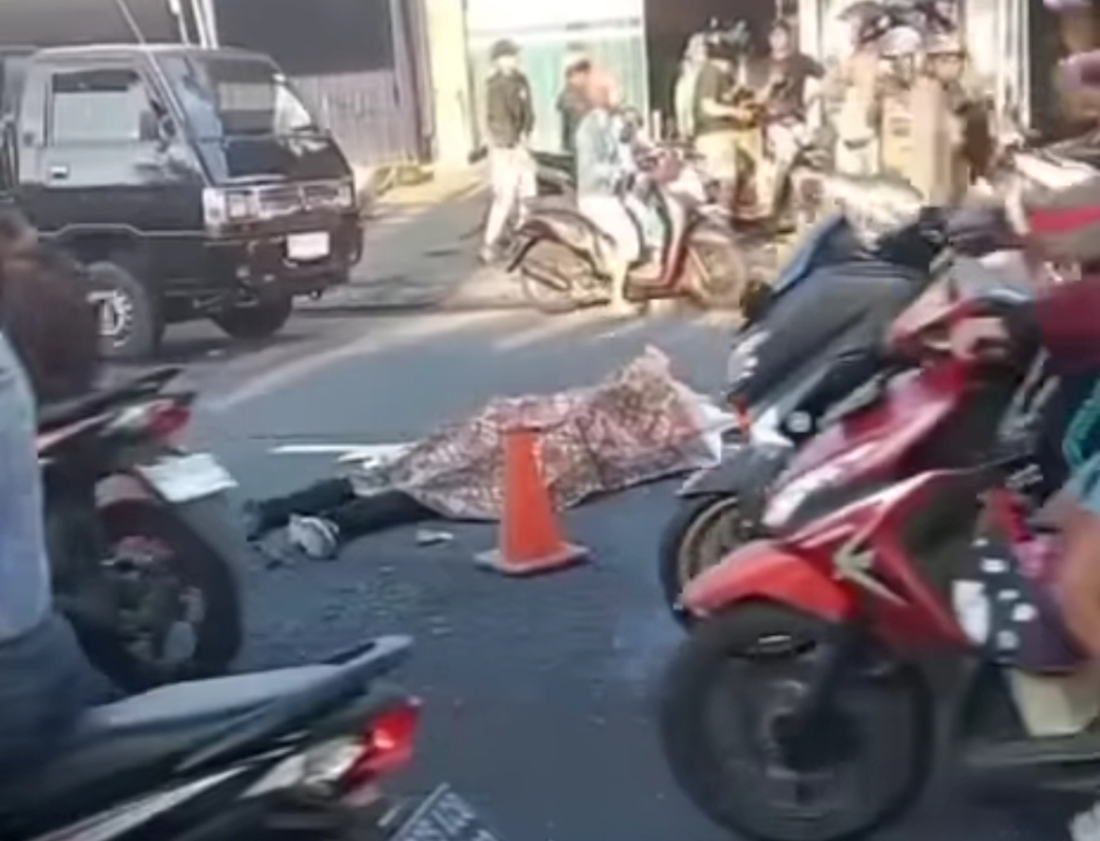 DITUTUPI: Jenazah Anshori ditutupi kain usai kecelakaan maut di Jalan Cokroaminoto, depan Warung Sari Nadi, Denpasar Utara, Bali, pada Jumat 1 September 2023.
