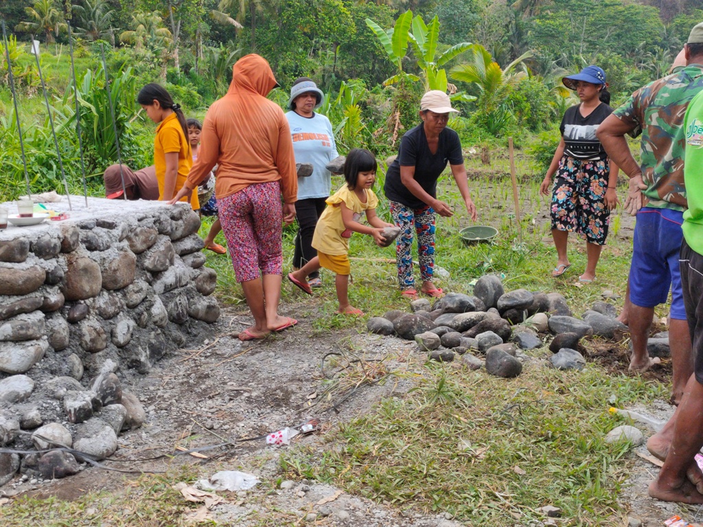 Warga dan beberapa siswa gotong royong membangun jembatan untuk akses ke sekolah mereka di SDN Ringdikit, Seririt, Buleleng, Bali.