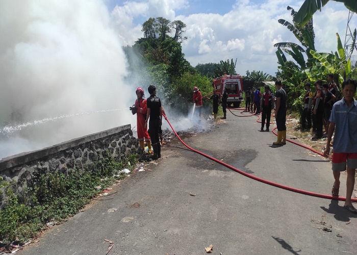 TERBAKAR : Proses pemadaman api di TPS Desa Adat Lepang yang terbakar, Minggu (3/9).