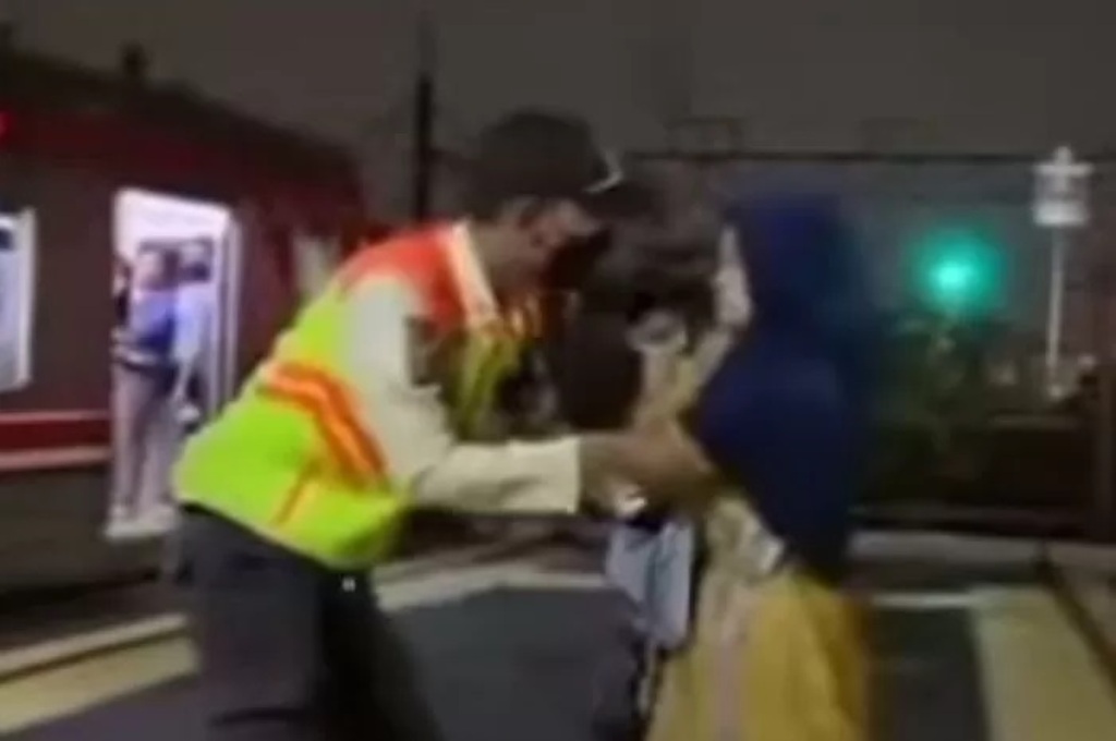 Ibu memakai kerudung menggendong bayi yang diduga mencoba mengakhiri hidup dengan melompat ke jalur kereta.
