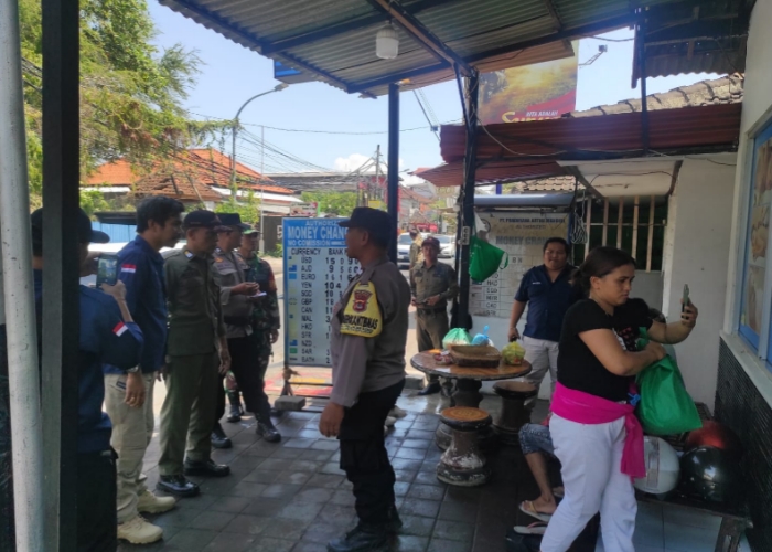 PEMBINAAN: Petugas gabungan saat memberikan pembinaan kepada money changwr di Kuta Selatan, Jumat (15/9).