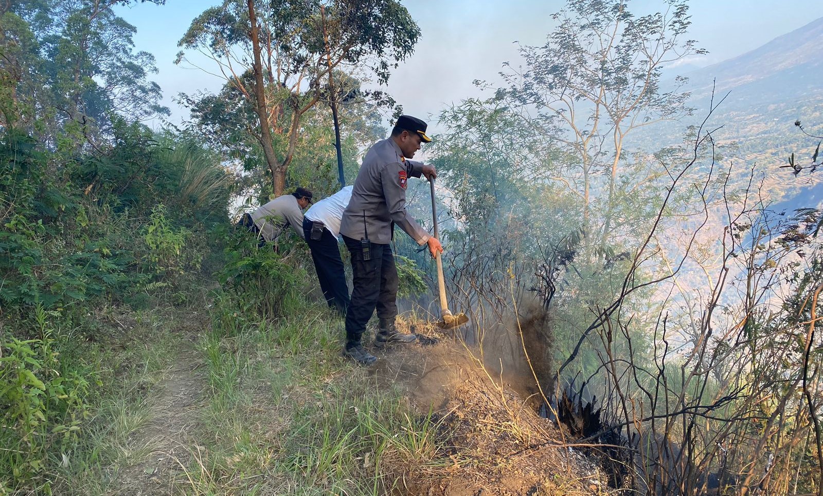 Polisi bersama masyarakat memadamkan kebakaran hutan di hutan lindung Belongan Bekul, wilayah Banjar Alengkong, Desa Songan B, Kecamatan Kintamani, Bangli.