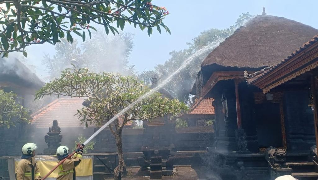 Pemadam kebakaran Kabupaten Badung bersama warga berusaha memadamkan api di atap palinggih Pura Dalem Adat Lambing, Badung, Kamis 12 Oktober 2023.