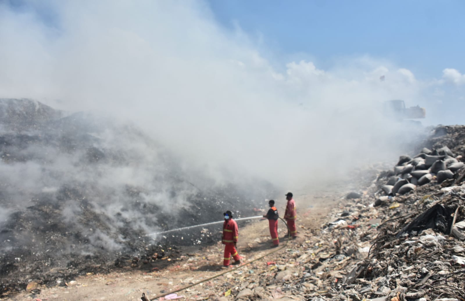 SEMPROT: Petugas pemadam kebakaran menyemprot tumpukan sampah yang terbakar di TPA Suwung.