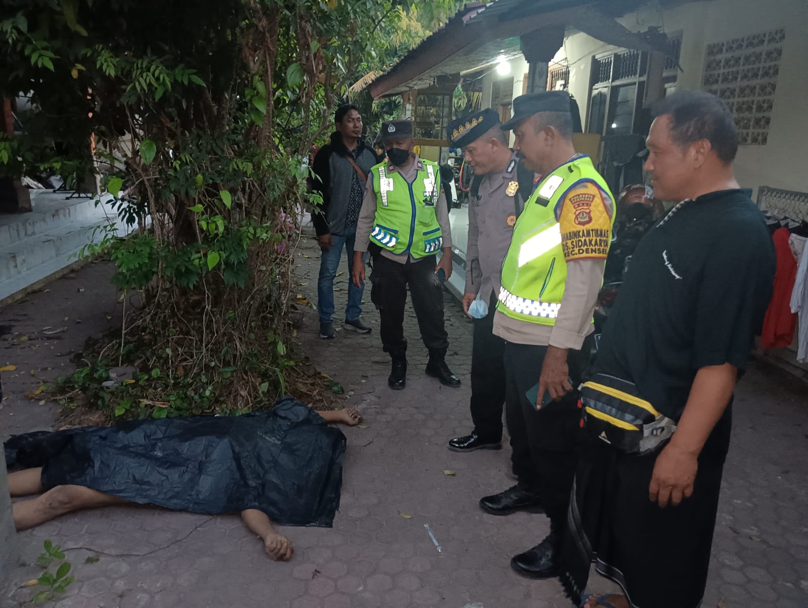 DITUTUPI: Jenazah Wilson yang hanya memakai celana dalam ditutupi dengan plastik warna hitam di tengah halaman. Sebelum meninggal korban sempat guling guling sambil teriak nama Tuhan.