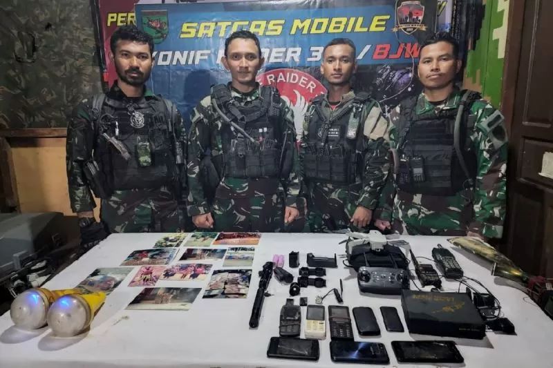 Satgas Yonif 300/BJW menunjukkan sejumlah barang bukti milik anggota KKB yang tewas tertembak saat kontak tembak, Jumat (20/10).