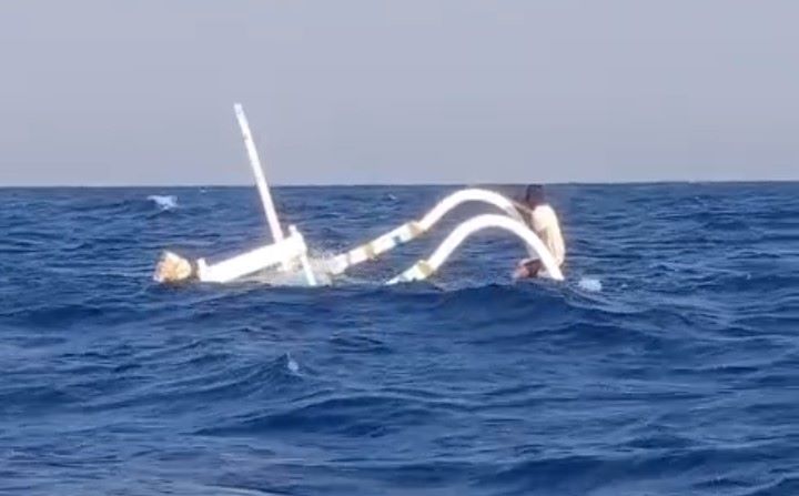 Jukung milik nelayan Karangasem I Ketut Darma Susila terbalik dihantam gelombang di perairan Amed, Desa Purwakerti.
