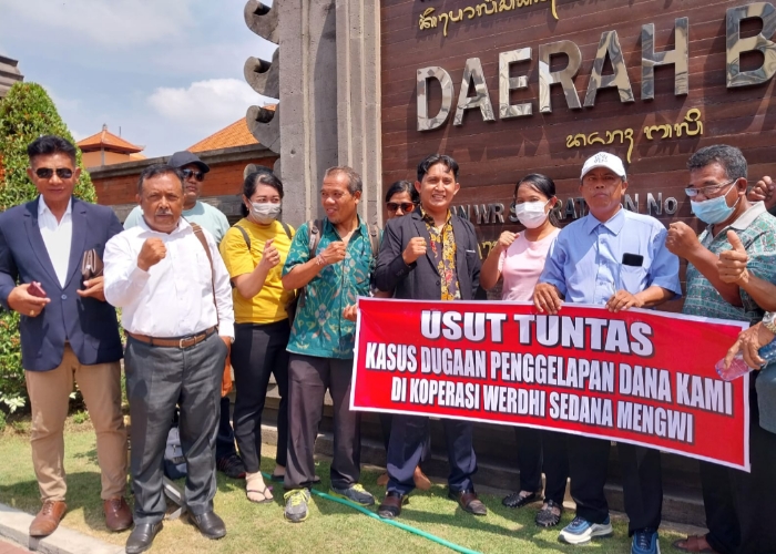 LAPOR: Nasabah koperasi mendatangi Polda Bali untuk melapor sambil membentangkan spanduk bertuliskan "Usut Tuntas Kasus Penggelapan Dana Kami di Koperasi Werdhi Sedana Mengwi".