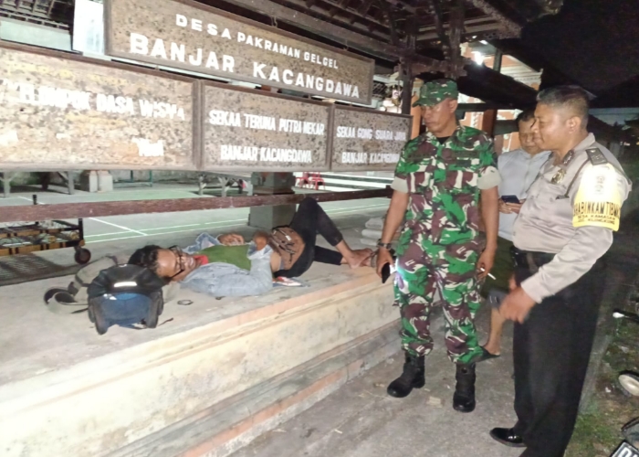 BIKIN HEBOH : Seorang pria tergeletak di depan balai banjar Kacangdawa dan diduga mabuk berat, Sabtu malam (18/11).