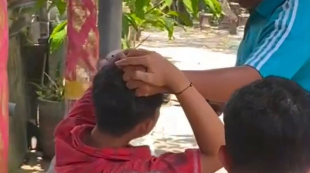 Tangkapan layar saat rambut F hendak dicukur oleh oknum guru di SMP Negeri 2 Kuta, Kabupaten Badung, Bali.