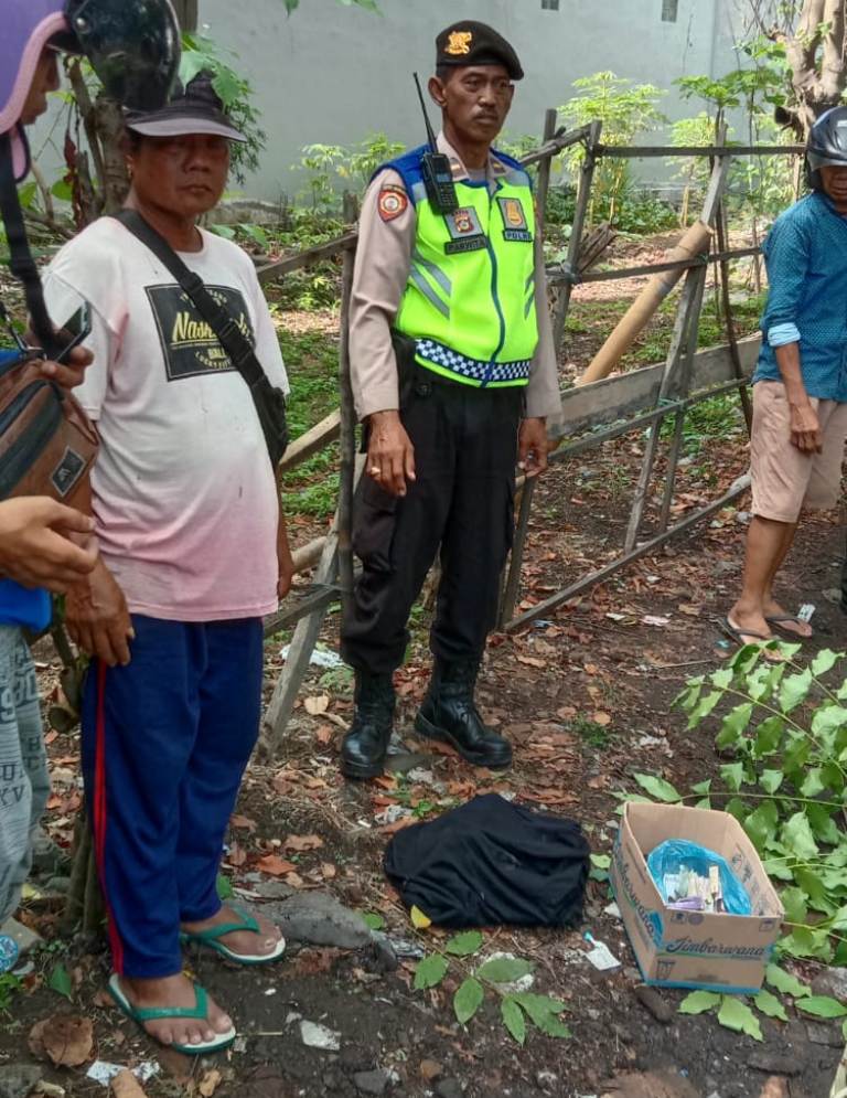 PERIKSA: Petugas kepolisian melakukan identifikasi terhadap jenazah bayi yang hancur, diduga karena terlindas mobil di Jalan Tukad Badung.