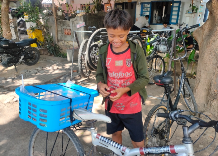 GIGIH : Rafa dan sepeda kesayangannya saat berkeliling Kota Singaraja jualan buah potong.