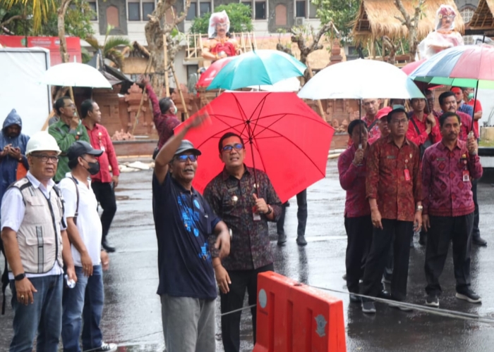 HUJAN : Bupati Tabanan diguyur hujan pantau pemasangan patung di RSUD Tabanan.