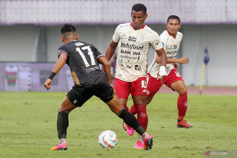 PUAS: Pemain Dewa United Ahmad Nufiandani (kiri) berebut bola dengan pemain Bali United Eber Bessa (tengah). Meski bermain imbang, Pelatih Riekerink merasa puas.