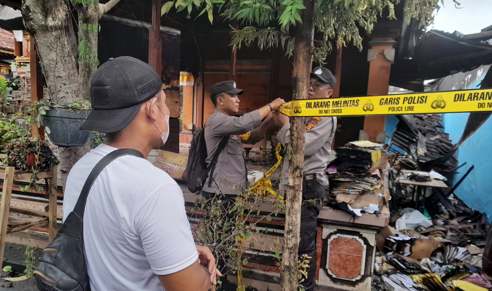 Polisi memasang police line  di lokasi kebakaran rumah Jalan Ratna Gang Mawar Nomor 16, Banjar Tatasan Desa Tonja, Kota Denpasar, Bali, Sabtu 9 Desember 2023.