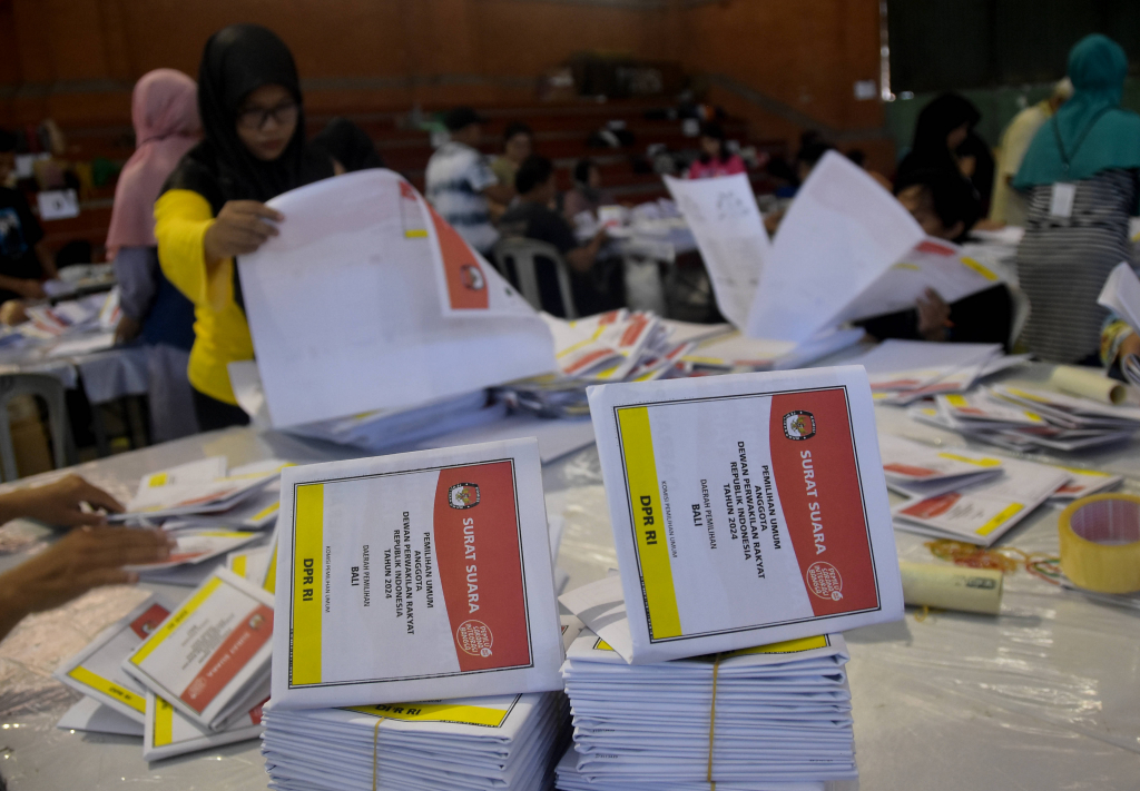 Sejumlah pekerja menyortir dan melipat surat suara legislatif DPR RI untuk Pemiilu 2024 di Gudang KPU Denpasar, GOR Kompyang Sujana, Rabu (13/12). Pelipatan suara sebanyak 507.000 ribu lembar