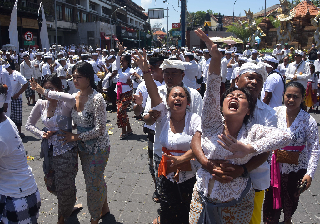 Warga mengalami Kerauhan  menusukan keris ke bagian tubuh saat Upacara Nangluk Merana Desa Adat Kuta, Minggu (10/12)