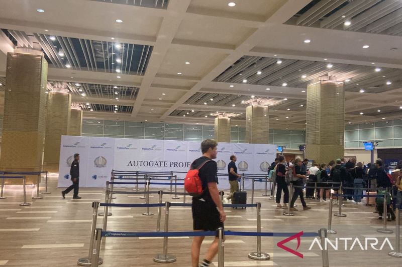 Seorang WNA melewati pemeriksaan imigrasi di tengah pemasangan perangkat pemeriksaan otomatis (autogate) di terminal kedatangan internasional Bandara I Gusti Ngurah Rai, Bali.