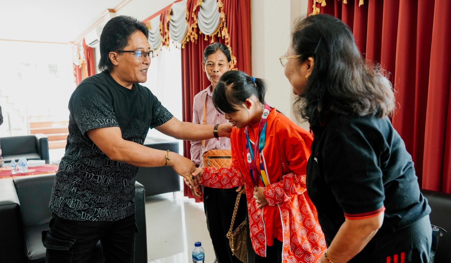 Bupati Badung I Nyoman Giri Prasta (kiri) menyerahkan bantuan kepada atlet penyandang disabilitas Ni Kadek Dwi Purwaningsih, Jumat, 12 Januari 2024.