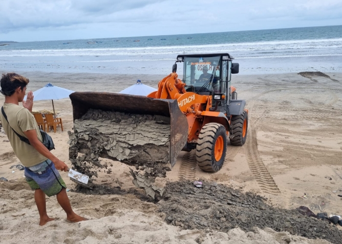 DIBONGKAR: Pembongkaran tanggul sementara berbahan karung berisi pasir di Pantai Kuta, Senin (15/1).