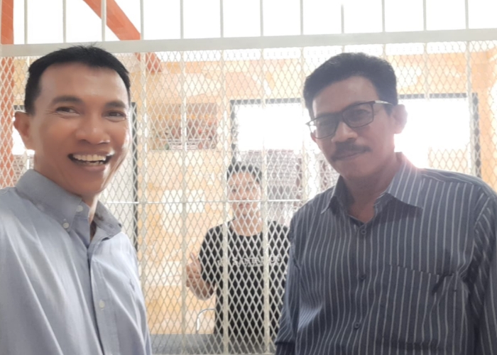 Jero Dasaran Alit dibalik jeruji besi saat dibesuk penasehat hukumnya.