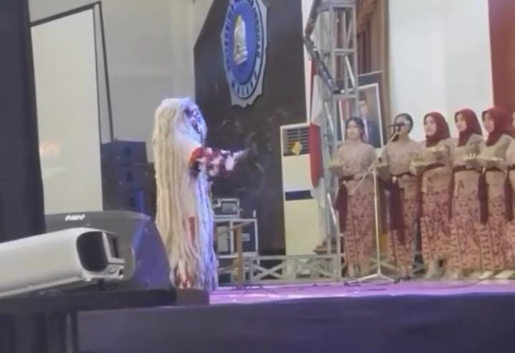 Paduan suaran dikomandoi dirigen dengan kostum rangda
